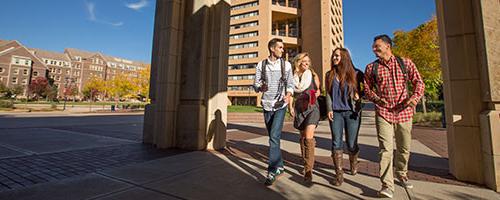 Four UNC student walking together on campus.